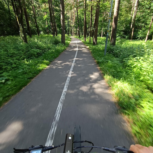 A person riding a bike on a road with a sign that says " i - m. ".