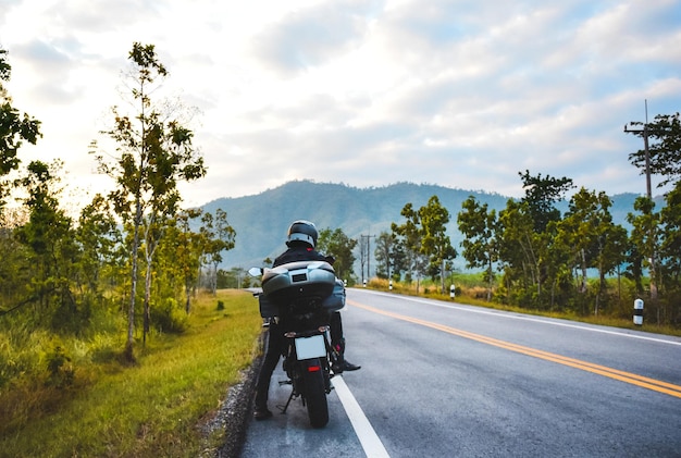 Photo person riding motorcycle on road against sky