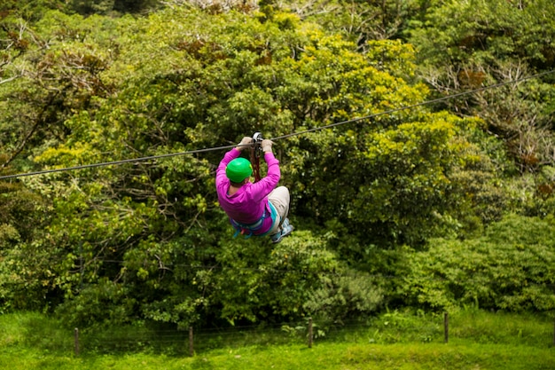 Photo a person riding zip line over rainforest at costa rica