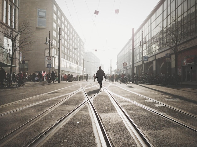 Person on road in city against sky