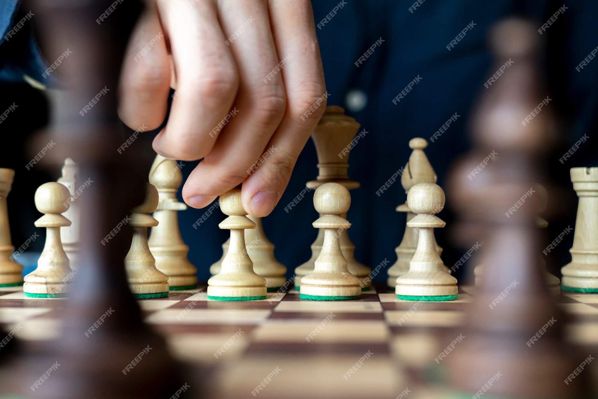 A skilled hand deftly slides a chess piece marked Chess across