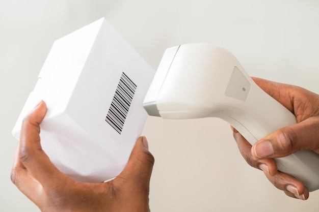 Person's Hand Using Barcode Scanner To Scan A Barcode