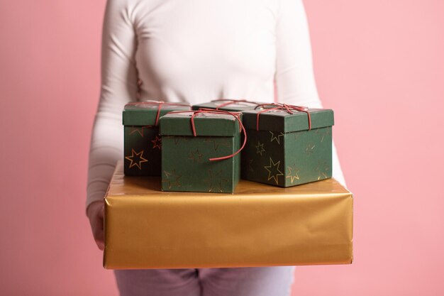 A person's hands hold holiday gift boxes