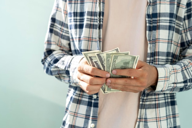 A person's hands holding and counting money in cash