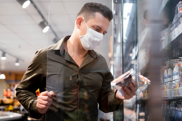 Foto persona che acquista con maschera facciale