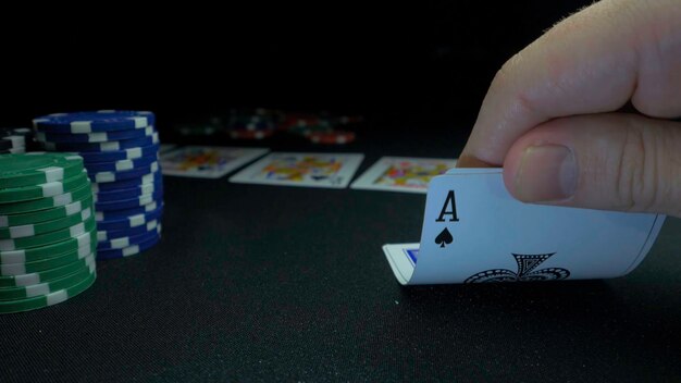 Foto persona che mostra il suo mazzo al gioco di poker giocatore di carte controlla la sua mano due assi in chip in