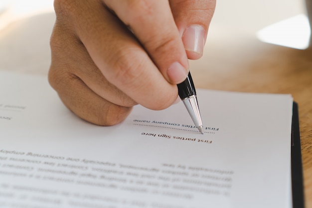 Person signing his name in document.