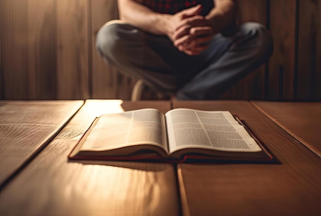 a person sitting on a wooden floor next to a bible in the style of bokeh panorama