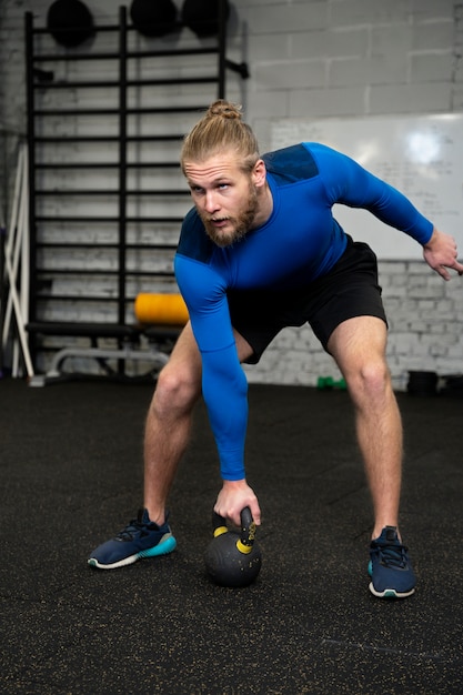 Persona in palestra sportiva con kettlebell