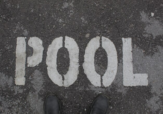 a person standing in front of a pool sign