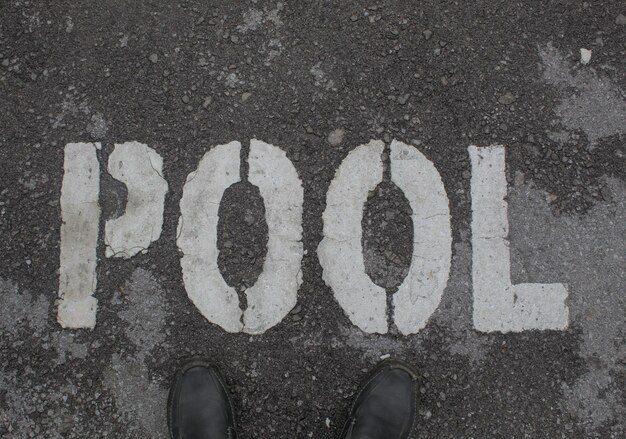 A person standing in front of a pool sign