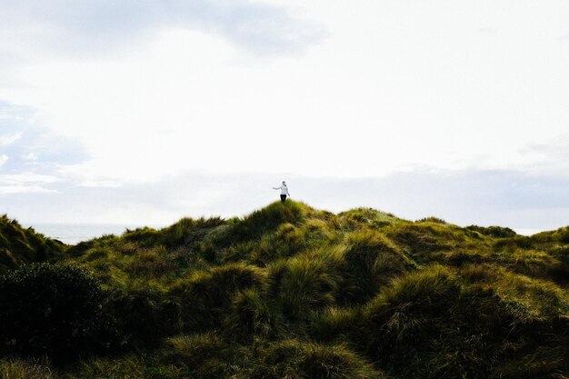 Person Standing on Green Grass Field Photo