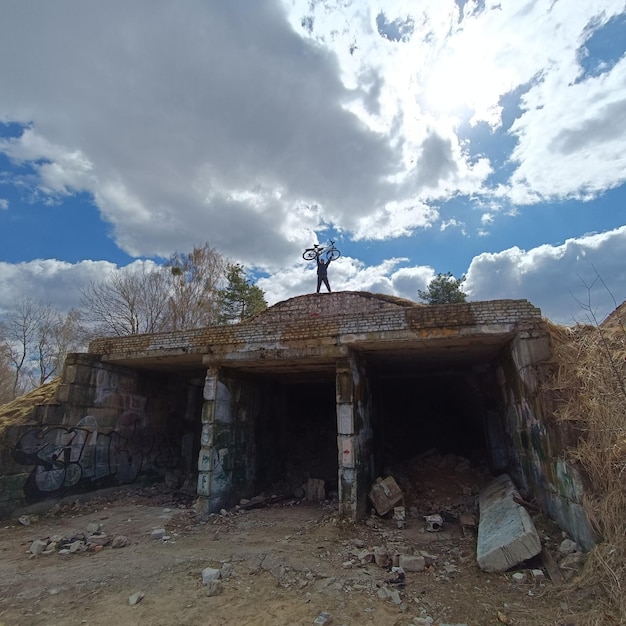 A person standing on a hill with a large tunnel in the background.