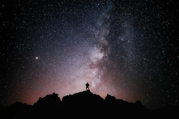 Foto una persona in piedi che guarda il campo stellare e la via lattea