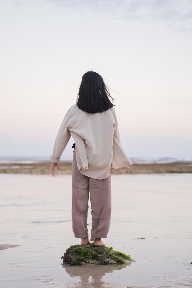 Photo 해가 지는 동안 로키 쇼어 에 서 있는 사람