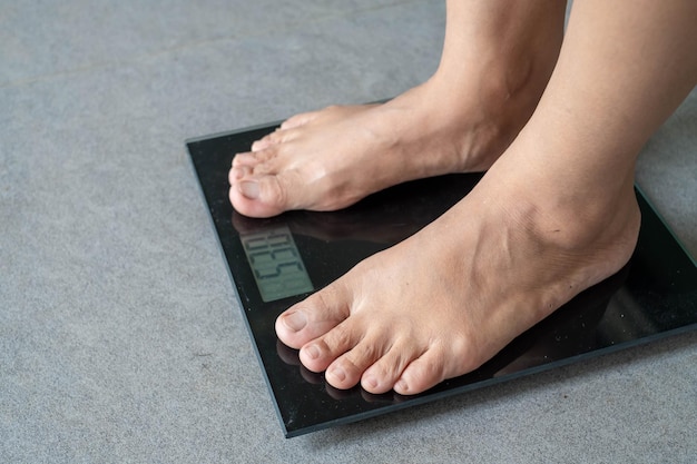 A person standing on a weight scale Premium Photo