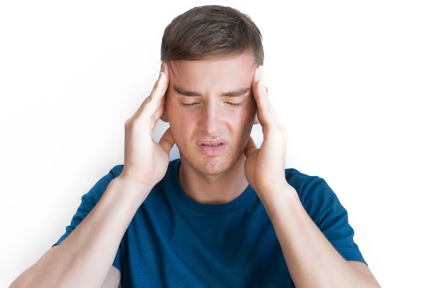 Person suffering from feeling pain because severe headache, migraine. Handsome nice guy, young annoyed upset man holding his head with hands, temples with fingers. Face expression