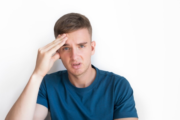 Person suffering from feeling sick, ill, pain because severe headache, migraine. Handsome guy, young sad upset man holding his head with hand, . Bad sad negative mood, face expression