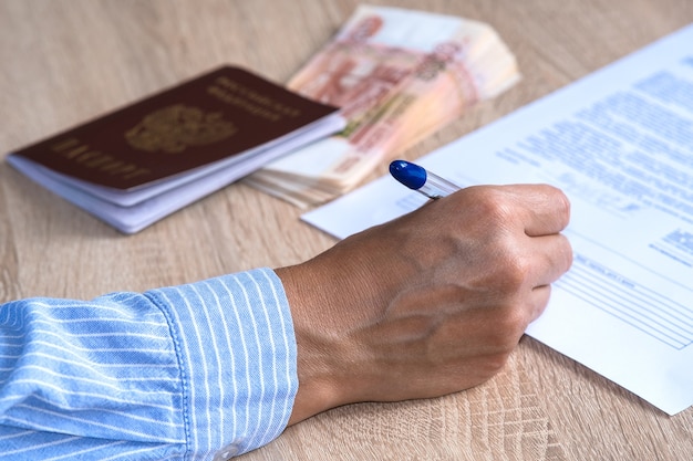a person takes out insurance and passes a survey on the table is a passport and a bundle of banknotes