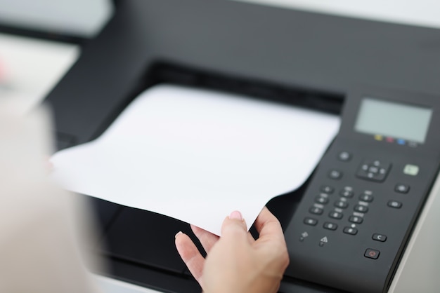 Person takes out white sheet from laser printer