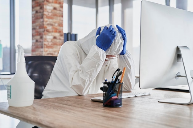 Photo person tired of working in uniform to protect against virus