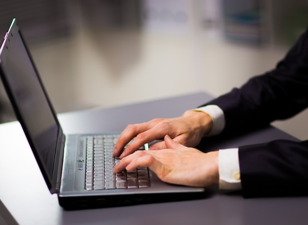 Person Typing on a modern laptop in an office