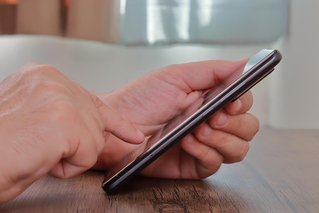 A person uses a smartphone that he holds in his hand