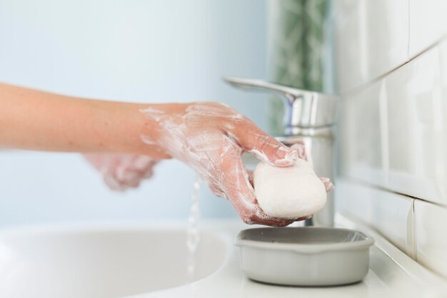 Person using bar of soap to wash their hands