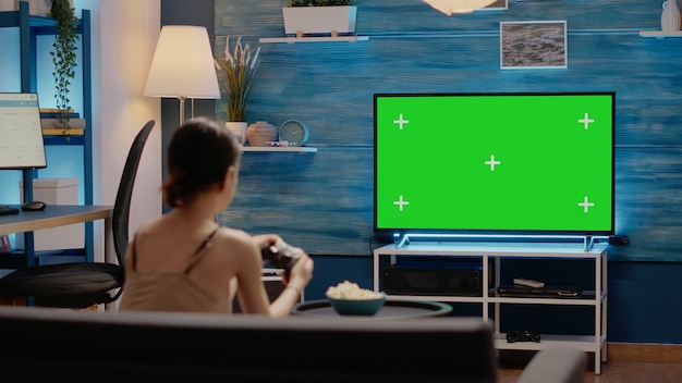 Person using joystick and green screen display on tv