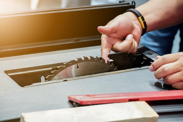 A person using a saw to cut a piece of wood