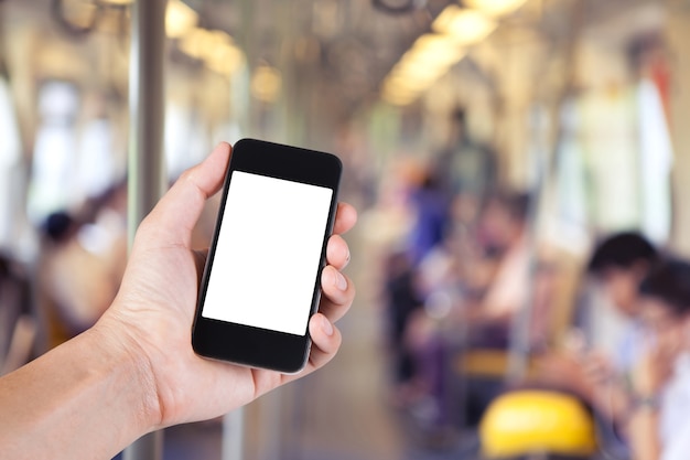 Persona che utilizza smartphone porta schermo bianco a portata di mano con sfondo sfocato di passeggero in skytrain nella grande città.