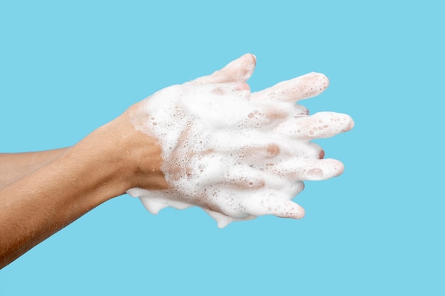 Person using soap on blue background