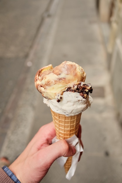 person walking along the road with an chocolate ice cream