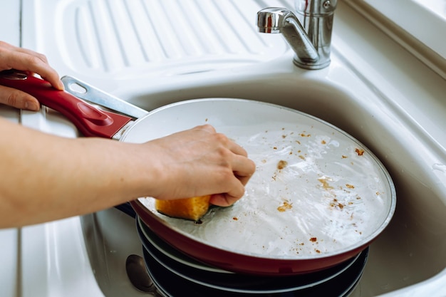 A person washing dishes in a sink