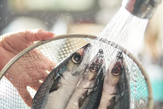 A person washing fish in a basket