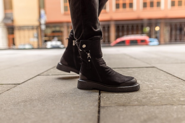 A person wearing black boots from the brand wool.