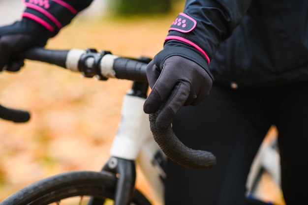 Photo a person wearing a black glove holds a bike handlebar with the word team on it.