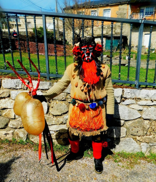 A person wearing a costume and a mask with a large gold ball on it