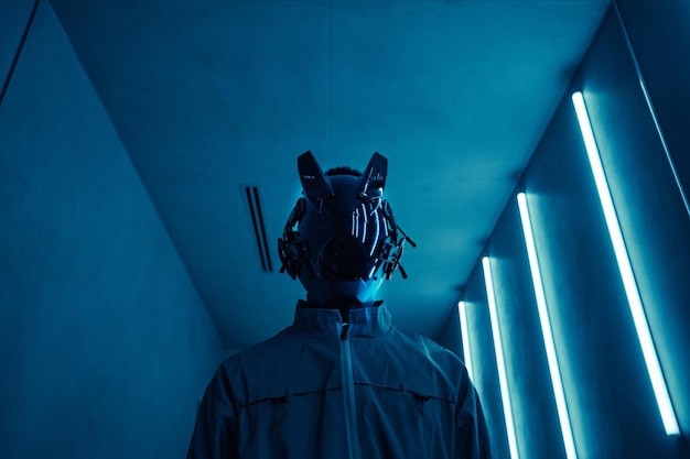 Person wearing cyberpunk robot mask in blue neon