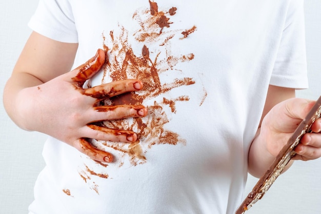 A person in a white shirt with chocolate. Stain on clothes