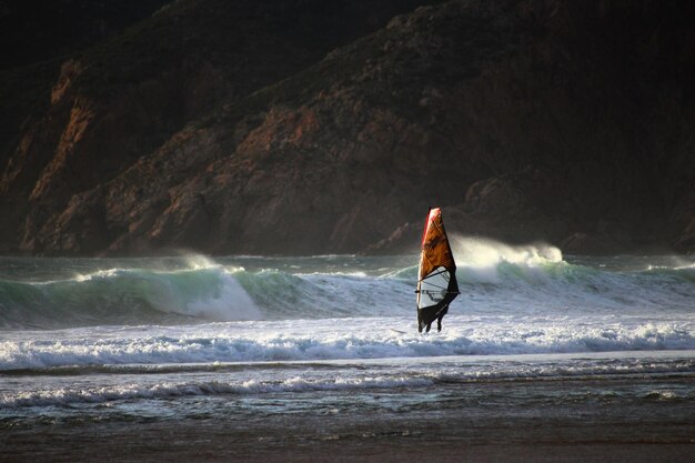 Person windsurfing in sea