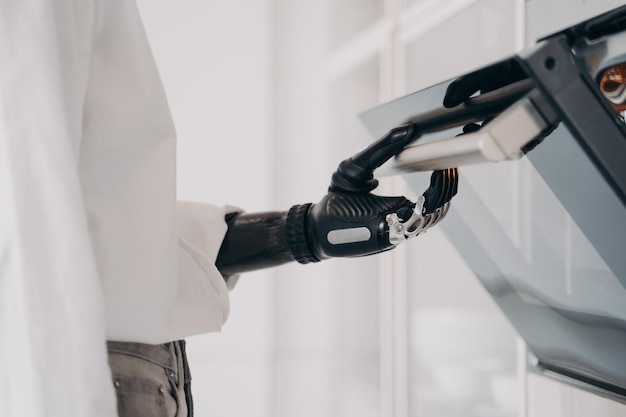 Person with disability cook opening oven using bionic prosthetic arm preparing dinner in kitchen