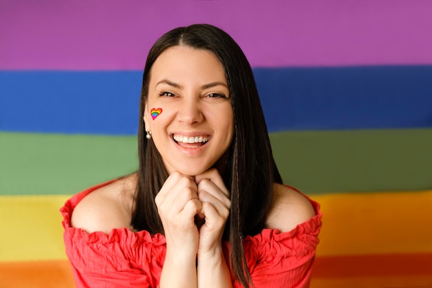 Person with a heartshaped LGBT flag painted on her cheek