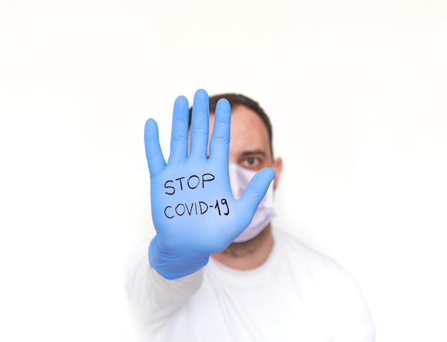 Photo person with outstretched hand in surgical glove with text coronavirus stop covid19