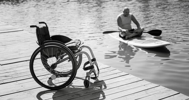 Foto persona con disabilità fisica cavalca su tavola sup