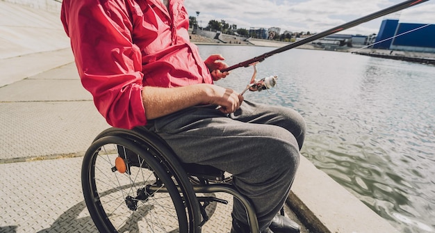 Person with a physical disability in a wheelchair fishing from fishing pier