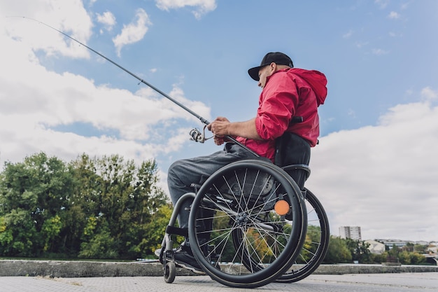 낚시 부두에서 낚시하는 휠체어에 신체 장애가있는 사람