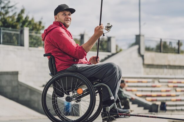 낚시 부두에서 낚시하는 휠체어에 신체 장애가있는 사람