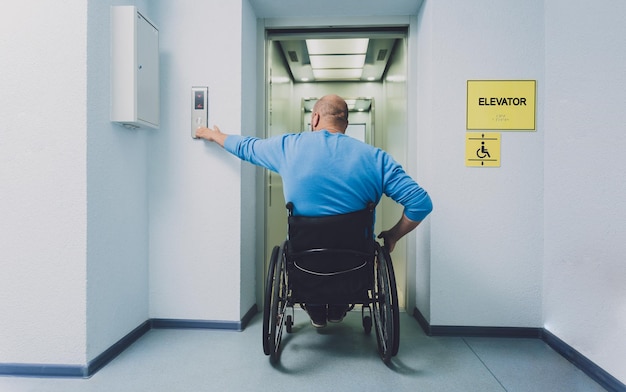 Person with a physical disability in a wheelchair using lift in building