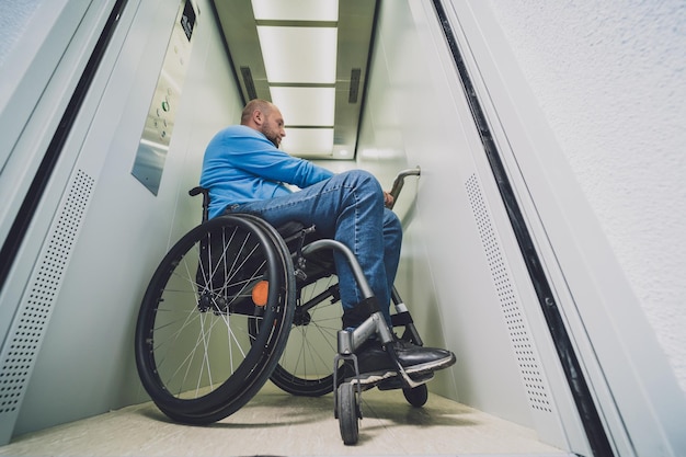 Person with a physical disability who uses wheelchair using\
lift in building